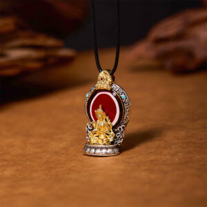 Hand-painted Tibetan dzi bead Avalokitesvara pendant close-up showing intricate gilt Bodhisattva details and red enamel inlay