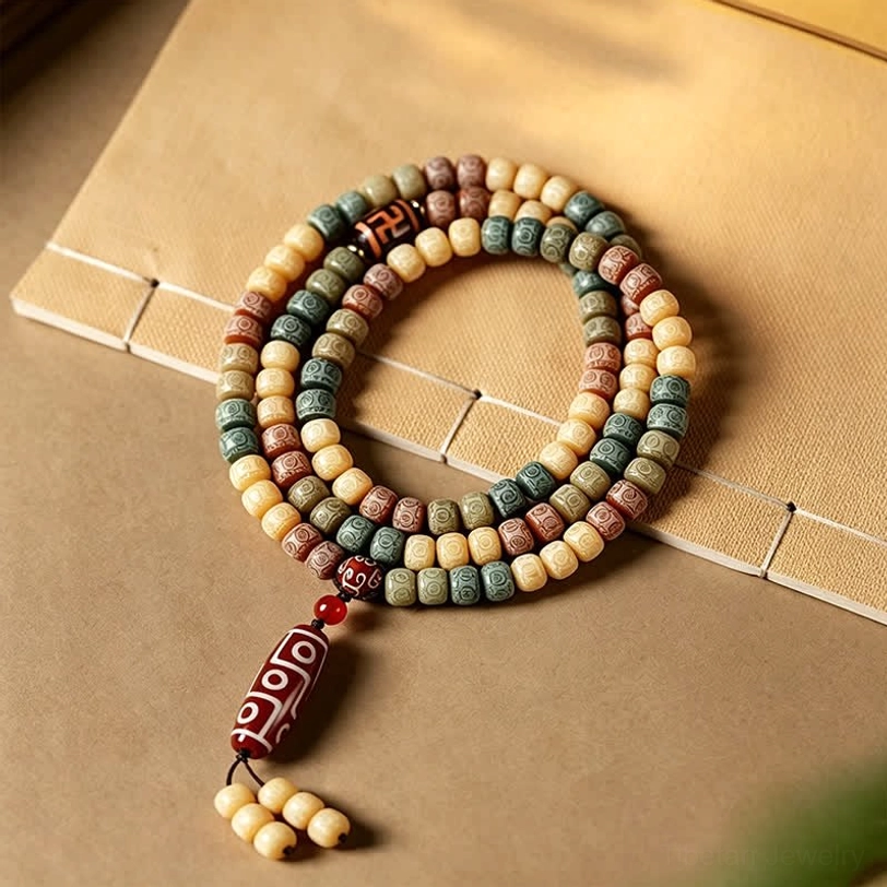 Authentic bodhi seed prayer beads mala with hand-painted dzi bead pendant on vintage paper background showing earthy barrel beads