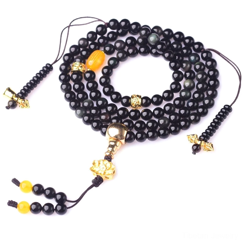 108 bead black obsidian prayer mala with adjustable yellow spacer beads and tassel, displayed on pure dark background