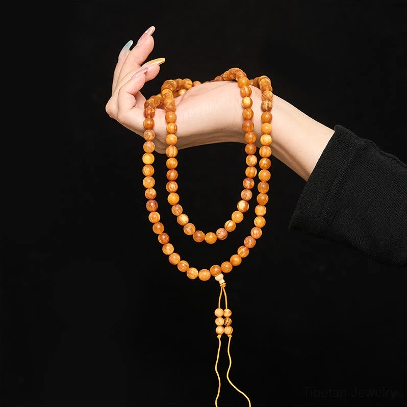 two-strand looped pine wood prayer mala held by hand showing neat arrangement of beads and authentic craftsmanship