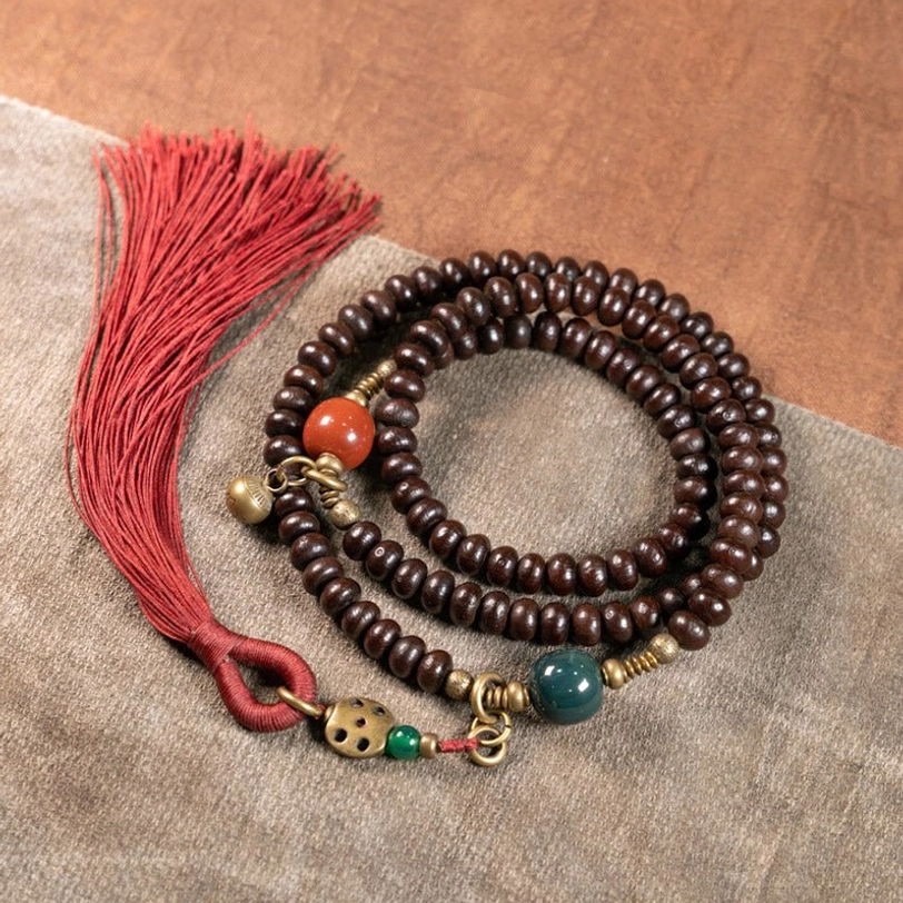 Tibetan 108-bead mala prayer beads overhead view showing purple bodhi seeds and vintage metal details