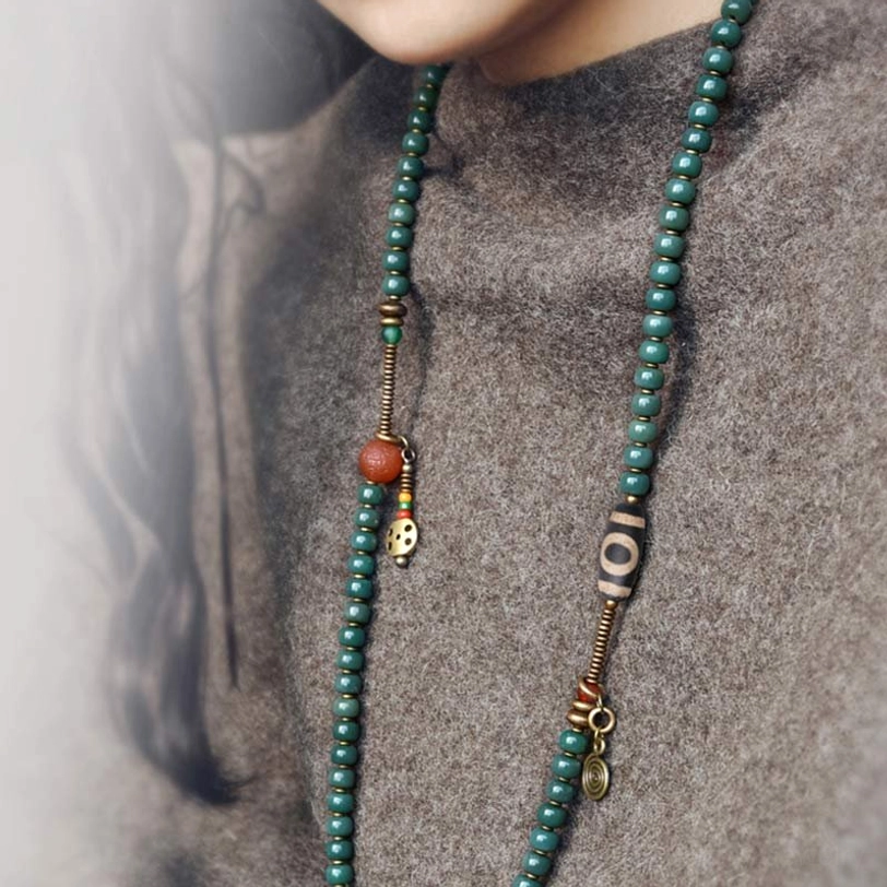 Two 108 Bodhi Prayer Necklaces with Nine-Eye and Patterned Dzi Beads Displayed on Gray Sweater