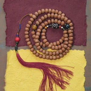 Full 108 mala bead necklace flat lay display with dzi bead accent, red tassel, and mixed spacer beads