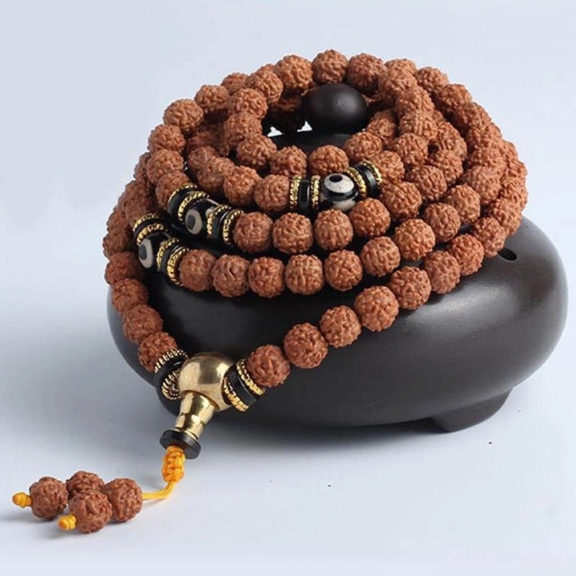 108 mala bracelet front view showing brown rudraksha seeds, black-white dzi spacers, gold metal accessories, and rudraksha tassel