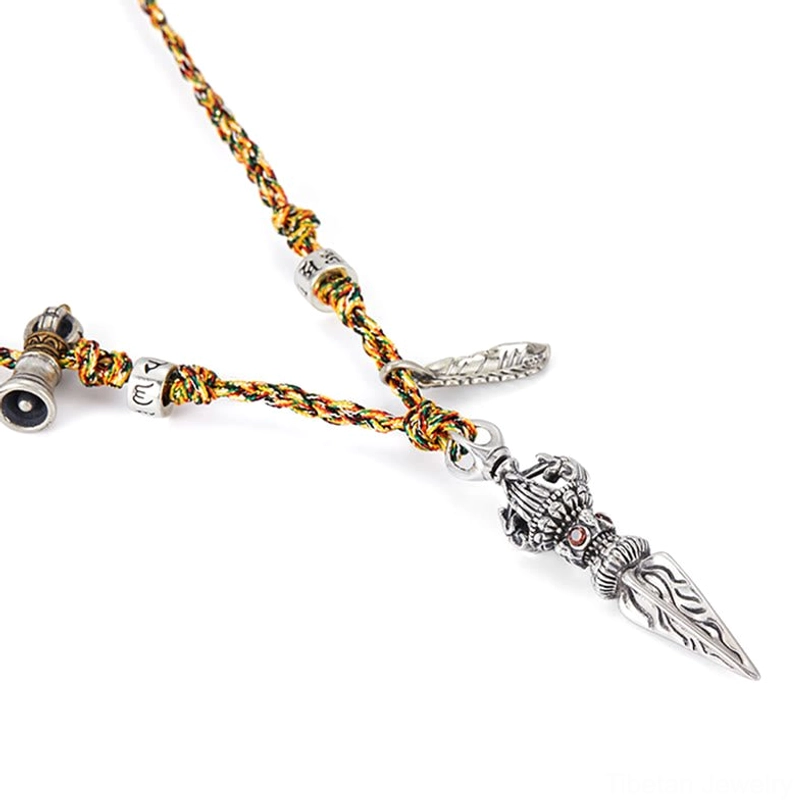 925 sterling silver Tibetan Dorje Vajra necklace showing fine handcrafted details and authentic patina on five-color braided cord