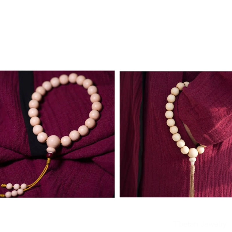 Red bead accent Abelia Biflora wood mala showing symbolic red beads among natural wood beads representing protection and compassion in Tibetan Buddhism
