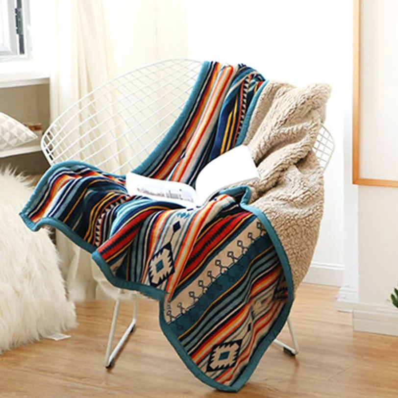 Wire chair accent blanket with fuzzy sherpa backside and geometric tribal pattern in sunlit reading corner, cozy home styling