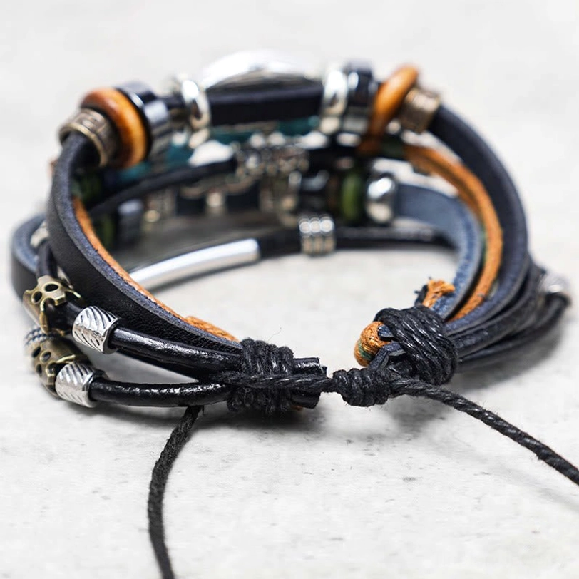 Adjustable multi-layer braided leather bracelet with knotted cord metal clasps and skull ornaments detail