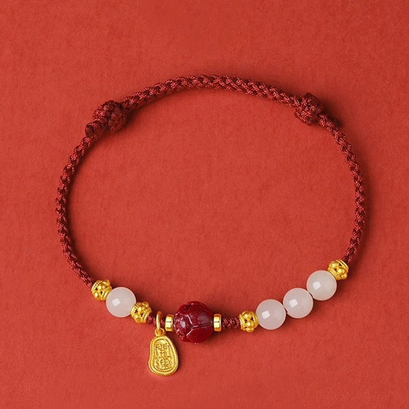 Adjustable red cord bracelet with sliding knot closure and white jade beads overhead view