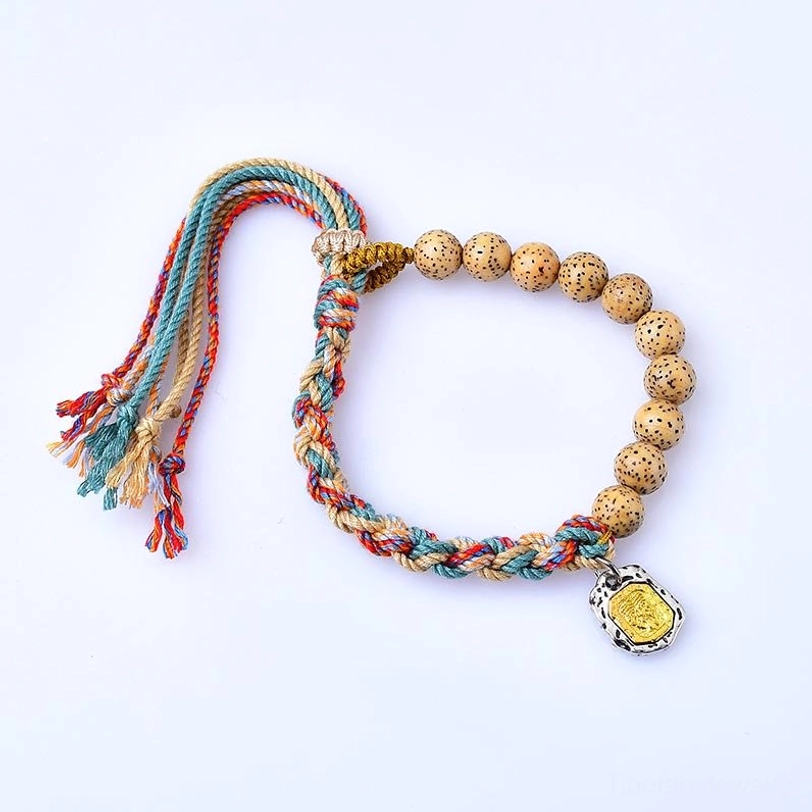 Adjustable Tibetan bodhi seed bracelet with multicolor tassel ends, metal wealth charm, and natural speckled beads