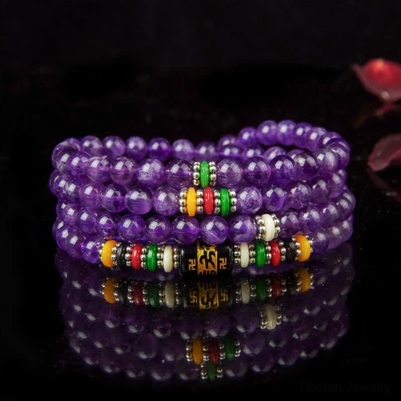Amethyst 108-bead mala bracelet with colorful mantra spacers displayed on dark background with mirror reflection