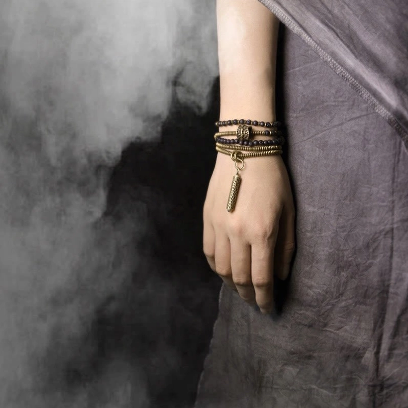 Antique brass and lava stone multilayered healing bracelets with dangling tassel on wrist