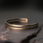 Antique copper Viking cuff bracelet with dual parallel bands, top-down view showing adjustable open design and brushed finish