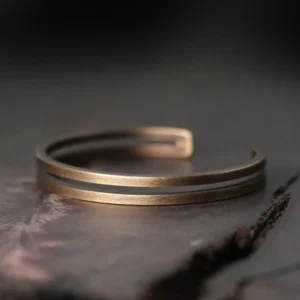 Antique copper Viking cuff bracelet with dual parallel bands, top-down view showing adjustable open design and brushed finish
