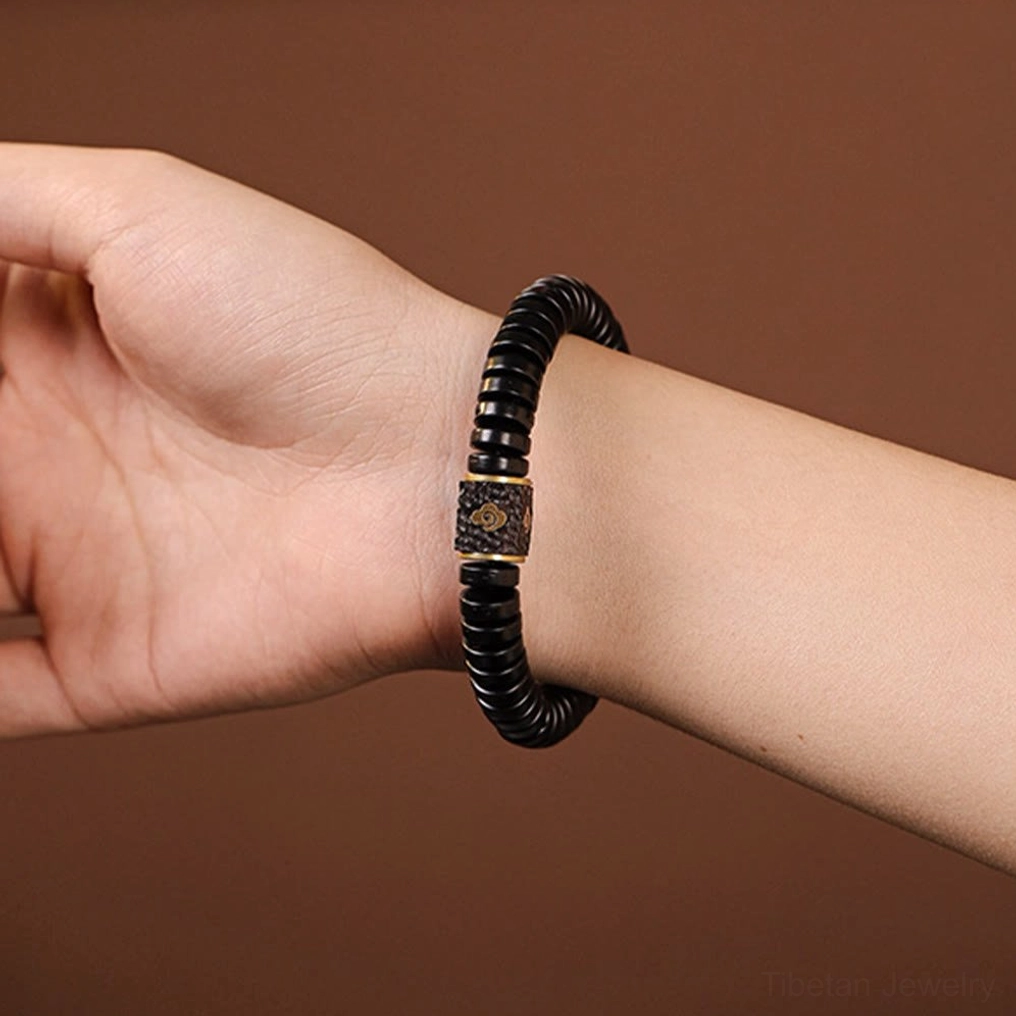 Tibetan coconut shell bracelet worn on left wrist showing actual size and wearable fit