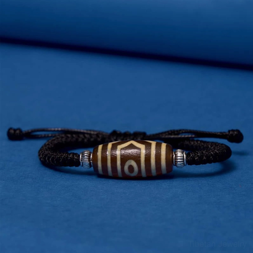 Authentic tibetan dzi bead natural material close-up showing hand-painted traditional design and quality