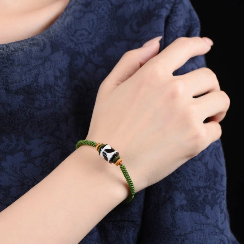 Authentic handcrafted dzi bead bracelet featuring sacred nine-eye symbol and premium green woven rope