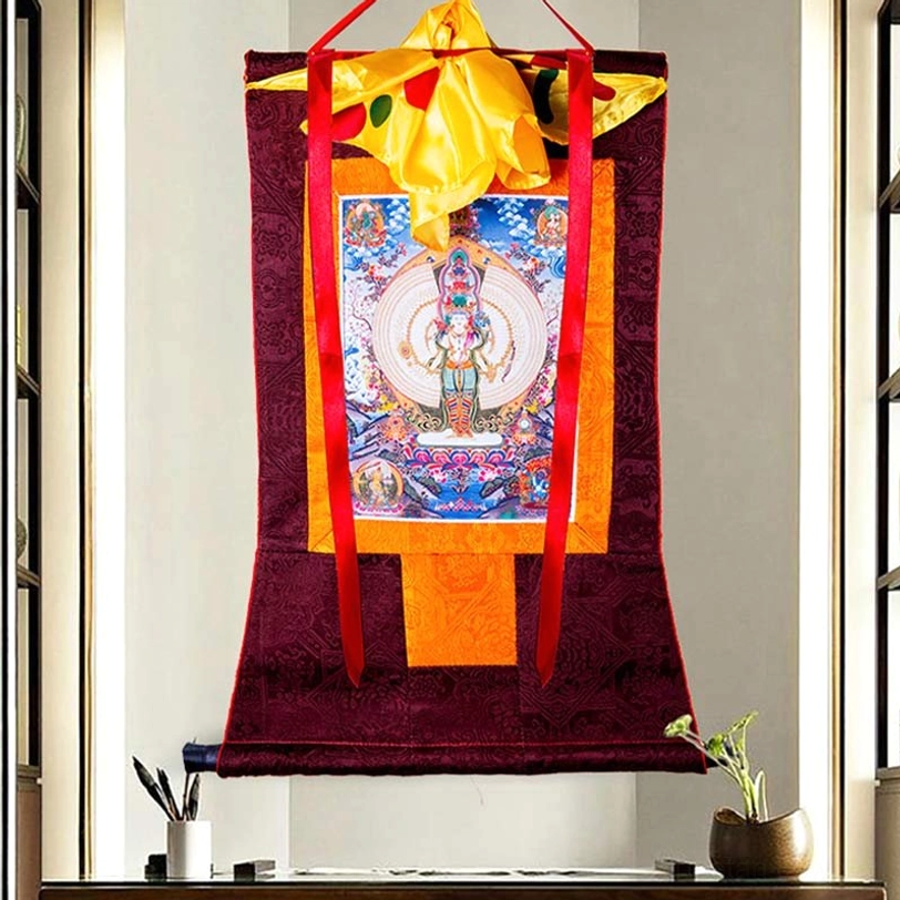 Thousand-armed Avalokitesvara thangka wall hanging with orange accent panel and colorful central deity artwork in home setting