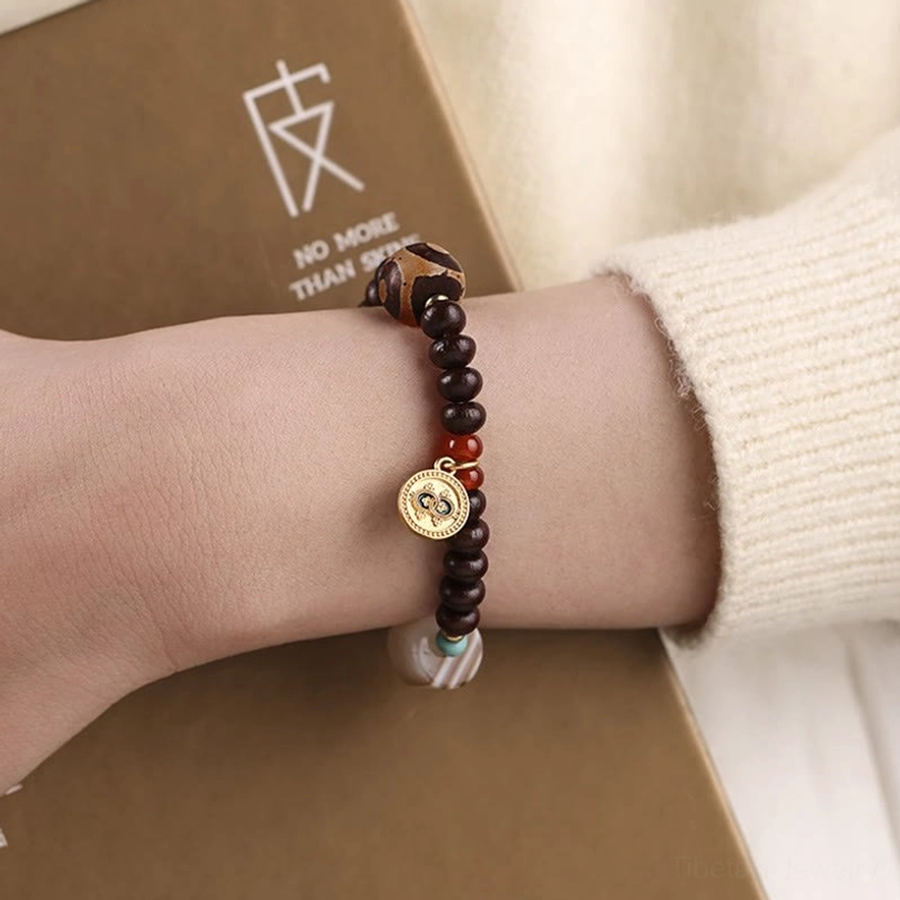Black God of Wealth Dzi bead bracelet with purple bodhi seeds, three-eye striped agate amulet, red agate, and turquoise accent beads