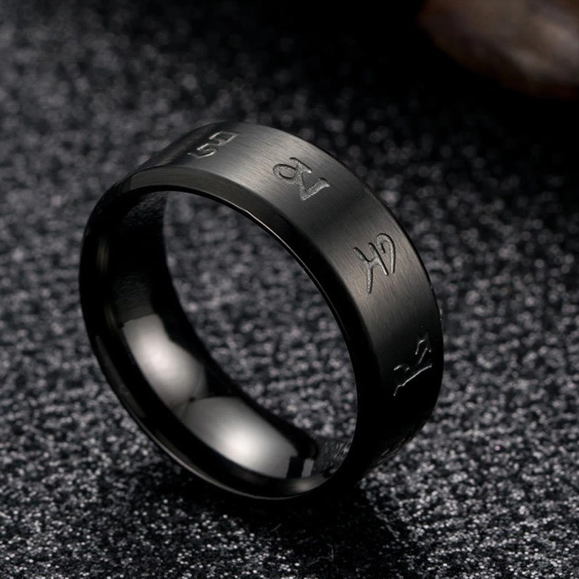 Black Jambhala Mantra ring standing oblique view against fabric background, showing engraved Buddhist mantras on ring band