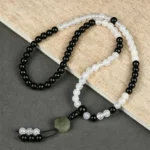 Black Obsidian Bagua protection bracelet with jade trigram charm displayed on wooden surface
