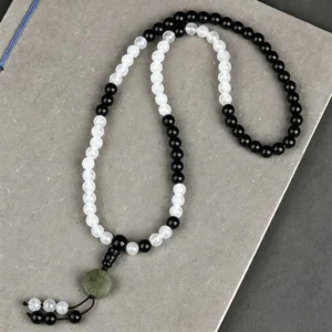 Full-length Black Obsidian beaded bracelet with Bagua symbol pendant flat lay view