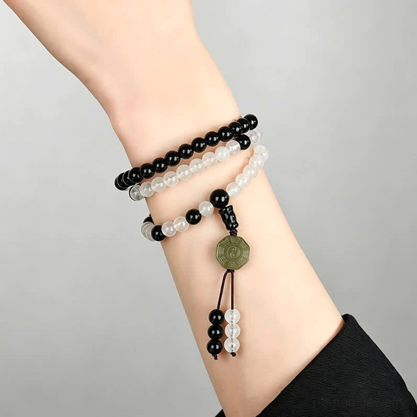 Three-layer Black Obsidian beaded bracelet stack on human wrist with trigram pendant detail