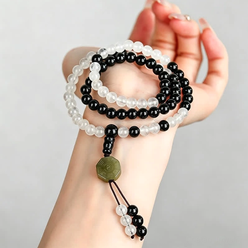 Multiple Black Obsidian Bagua bracelets worn together on wrist showing layering style