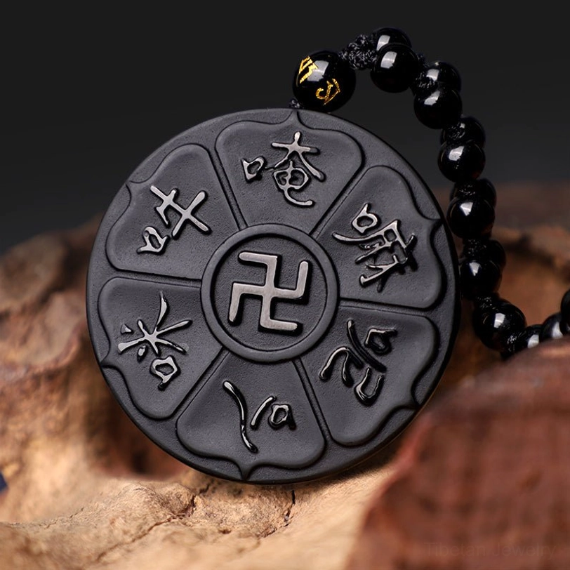 Handcrafted black obsidian Buddhist mantra pendant featuring six-syllable mantra and swastika symbol with embossed silver text detail
