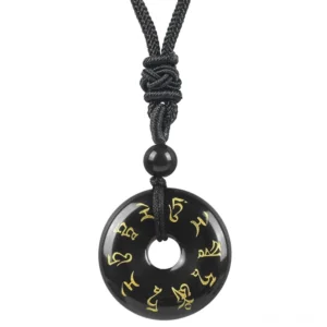 Black Obsidian Green Tara mantra pendant close-up, showing golden Sanskrit engraving with knotted black braided cord and accent bead