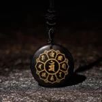 Black Obsidian Om Mani Padme Hum mantra pendant necklace with golden Sanskrit engravings and black braided rope