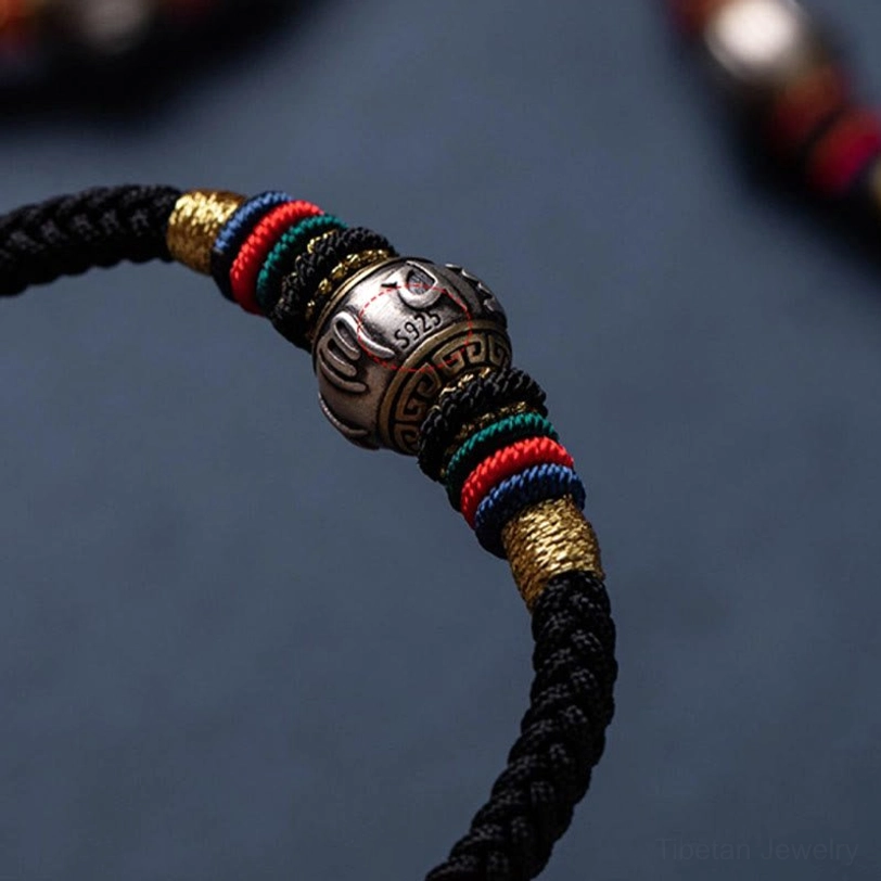 Black Om Mani Padme Hum Tibetan protection bracelet with silver mantra charm for spiritual grounding