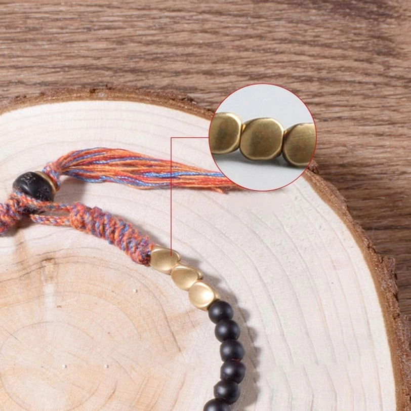 Magnified view of Tibetan onyx bracelet gold metal spacer beads and braided tassel showing authentic handmade details