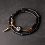 Black Onyx Dzi Bead Double Wrap Protection Bracelet with antique copper cone pendant flat lay display