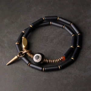 Black Onyx Dzi Bead Double Wrap Protection Bracelet with antique copper cone pendant flat lay display