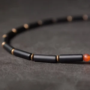 Single strand Black Onyx tube beads with copper spacers and red agate accent detail close-up