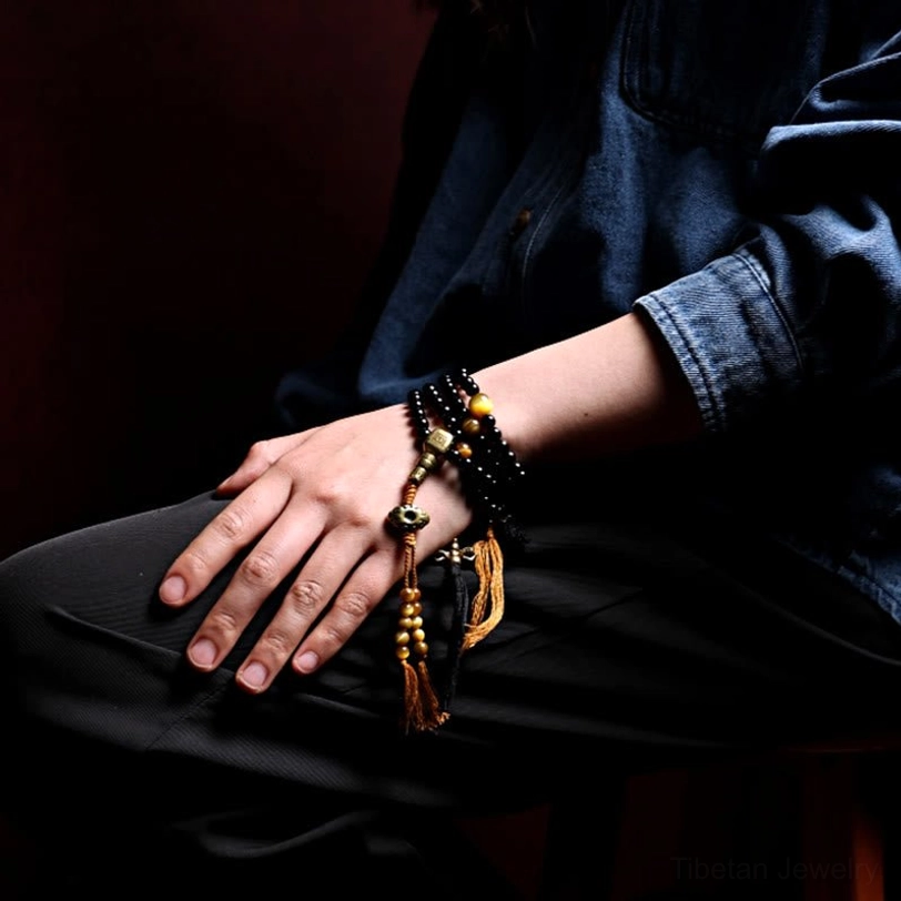 Black onyx mala bracelet with authentic cotton tassel and copper accents showing all three style variations side by side