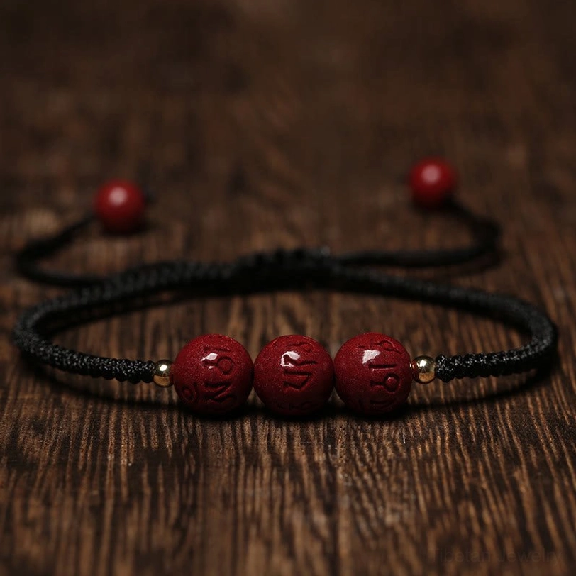 Black rope Tibetan cinnabar bracelet with deep red engraved beads and adjustable knot design flat lay photography