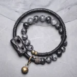 Black rutilated quartz ebony wood copper couple bracelet set flat lay with brass bell charm