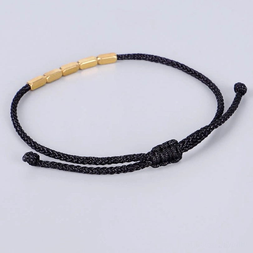 Black Tibetan braided string bracelet with gold copper barrel beads and adjustable knot closure