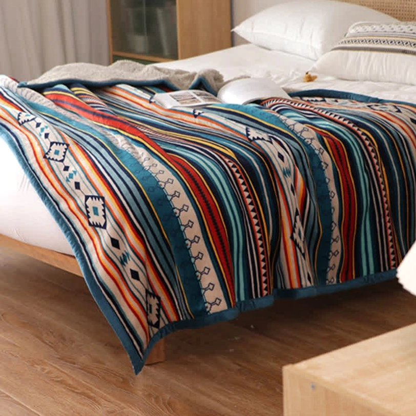 Close-up of throw blanket edge binding showing quality construction, blue trim detail, and durability of geometric Tibetan pattern blanket