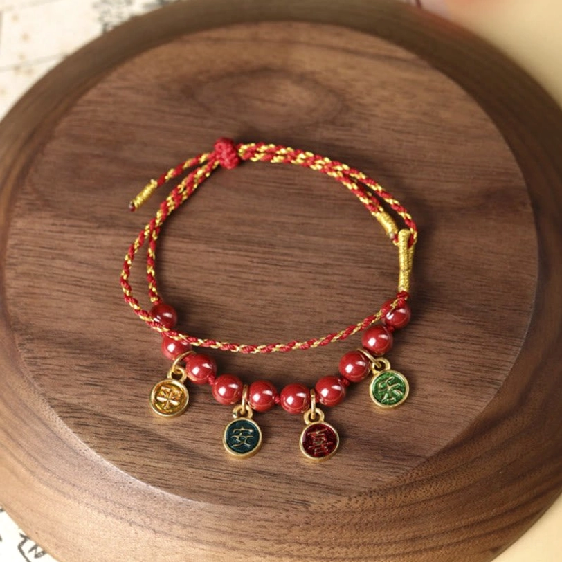 Peace and joy blessing bracelet close-up on round wooden board, featuring dual-tone braided cord with metal enamel charms