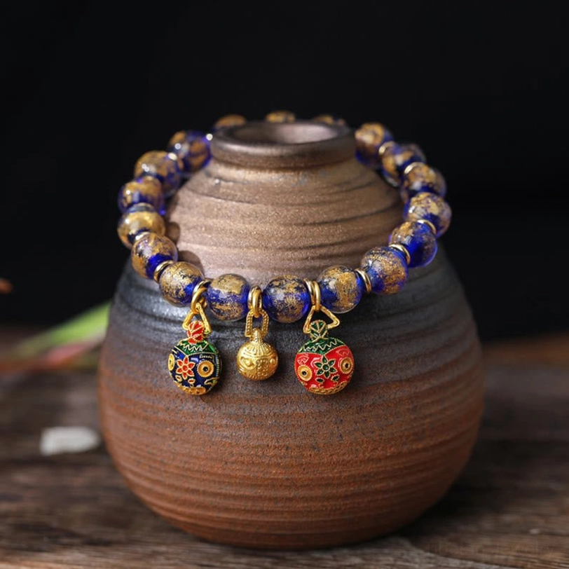 Blue gold tone tibetan swallowing beast bracelet with liuli glass beads in pottery jar