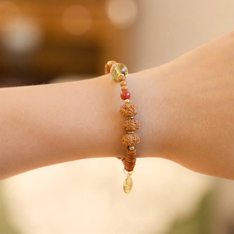 Tibetan bodhi seed bracelet on wrist with clear crystal and small gold pendant charm