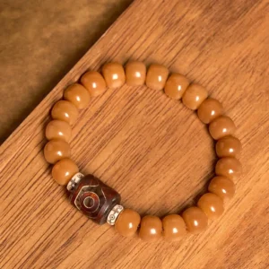 Tibetan Bodhi Seed Dzi Bead bracelet flat lay - warm brown natural beads with hand-painted protective amulet bead