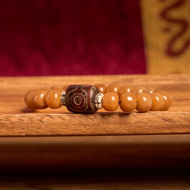 Bodhi Seed Dzi Bead bracelet side profile - showing elastic band construction and bead arrangement on wooden surface