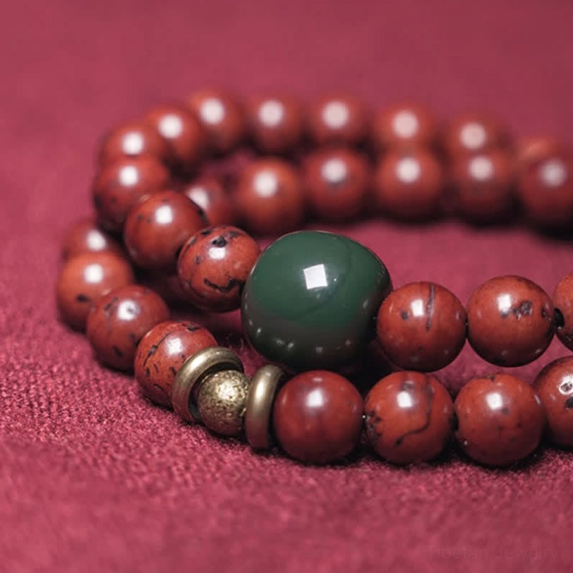 Close-up detail of bodhi seed beads and large green jade focal bead with textured stone surface