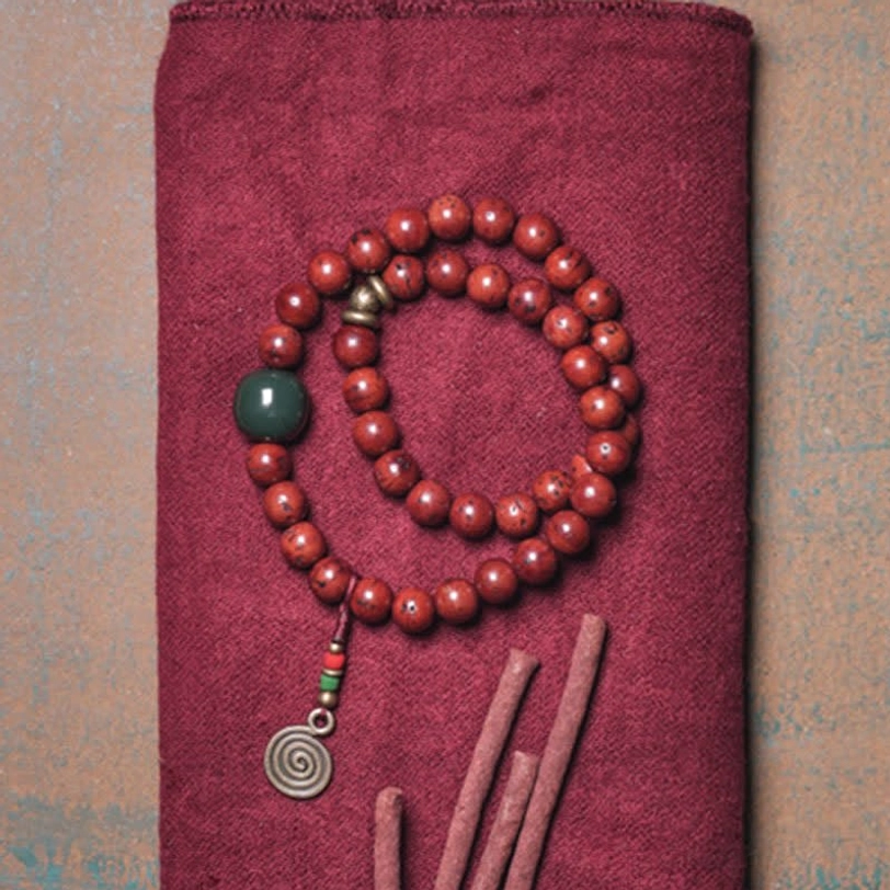 Handmade mala bracelet flatlay with incense sticks featuring bodhi seeds and jade beads