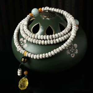 Handcrafted bodhi seed agate mala bracelet with multicolor beads on green incense holder, meditation setup