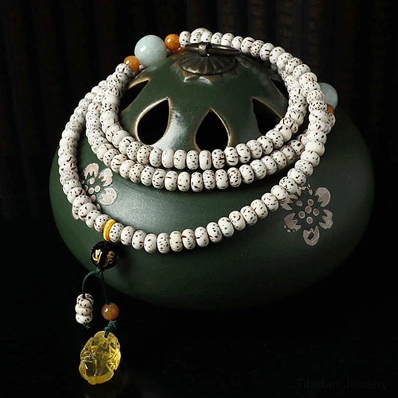 Handcrafted bodhi seed agate mala bracelet with multicolor beads on green incense holder, meditation setup